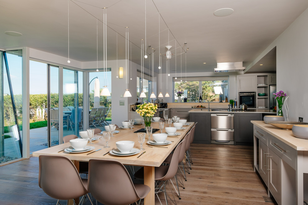 Idee per una sala da pranzo aperta verso la cucina classica con pareti bianche e pavimento in legno massello medio