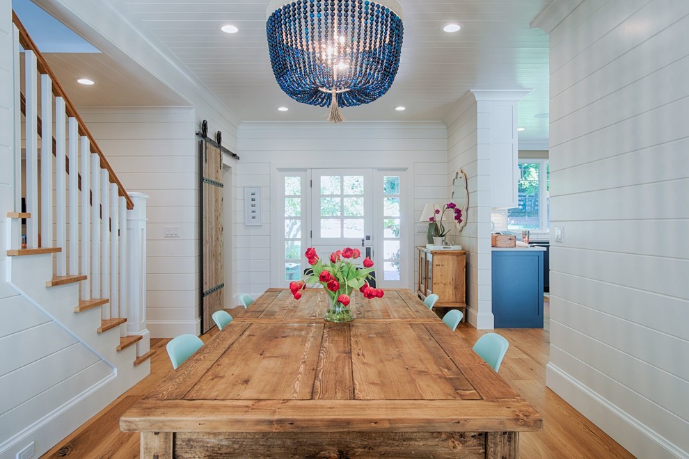 Cette photo montre une salle à manger ouverte sur la cuisine nature de taille moyenne avec un mur blanc, parquet clair, aucune cheminée et un sol beige.