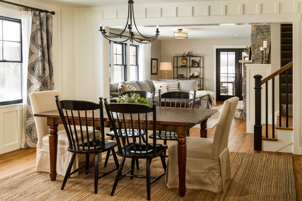 Design ideas for a farmhouse open plan dining room in Minneapolis with white walls, medium hardwood flooring and feature lighting.