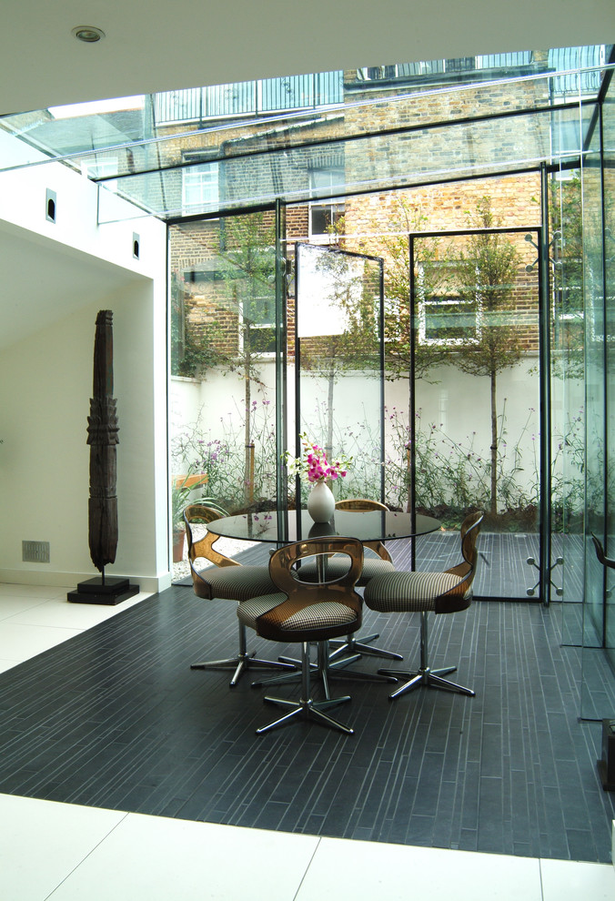Modernes Esszimmer mit weißer Wandfarbe und Keramikboden in London