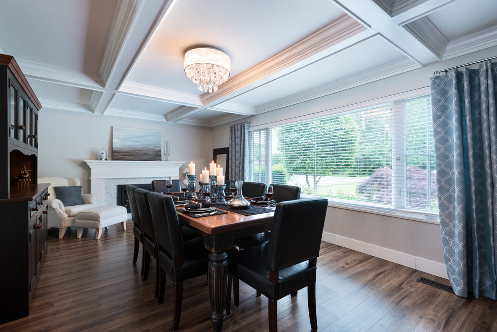 Aménagement d'une grande salle à manger ouverte sur la cuisine classique avec un mur gris, un sol en vinyl, une cheminée standard, un manteau de cheminée en carrelage et un sol marron.