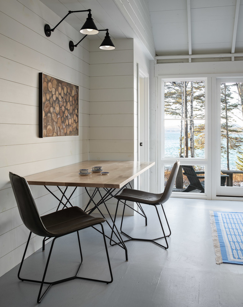Aménagement d'une salle à manger bord de mer avec un mur blanc, sol en béton ciré et un sol gris.