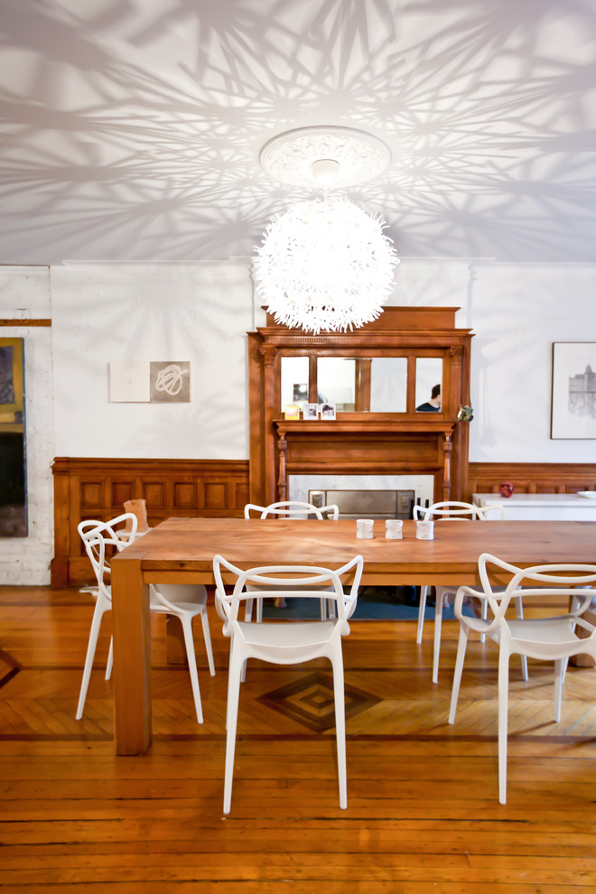 На фото: столовая в современном стиле с белыми стенами и паркетным полом среднего тона