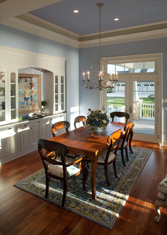 Стильный дизайн: столовая в морском стиле с синими стенами, паркетным полом среднего тона и коричневым полом без камина - последний тренд