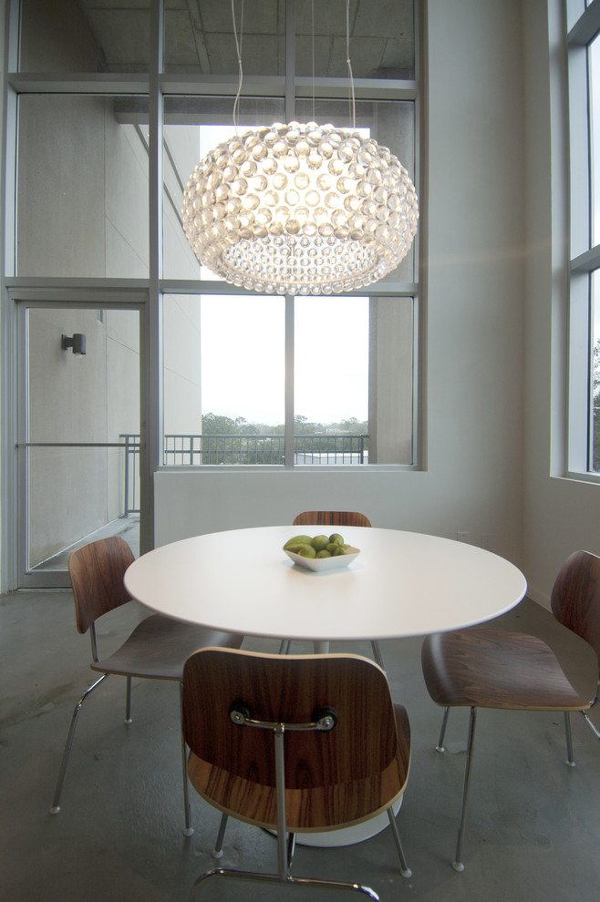 This is an example of a contemporary dining room in Houston with white walls.