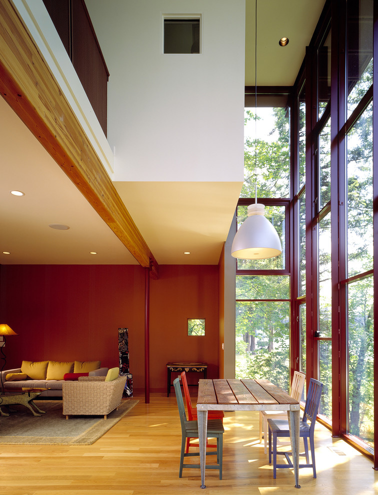 Esempio di una sala da pranzo minimal con pareti rosse, parquet chiaro e pavimento marrone