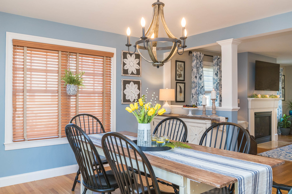 Cette photo montre une salle à manger nature avec un mur bleu, un sol en bois brun, une cheminée standard et un sol marron.