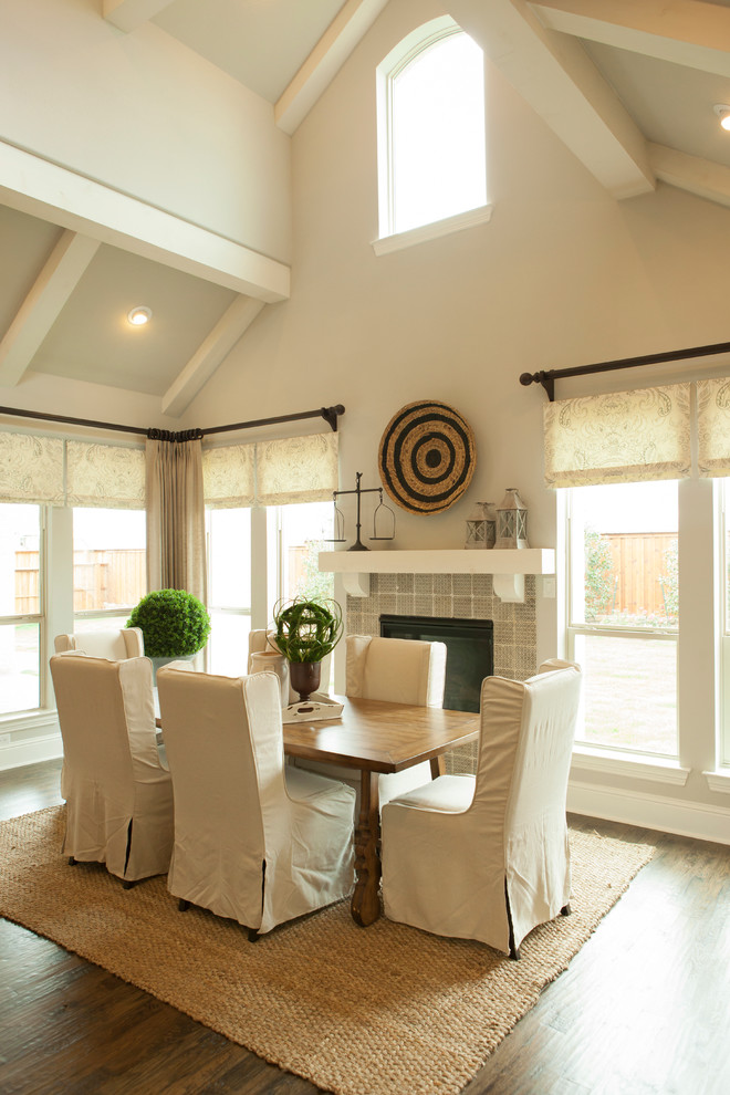Cette photo montre une salle à manger chic avec un mur beige, parquet foncé, un manteau de cheminée en carrelage et une cheminée standard.