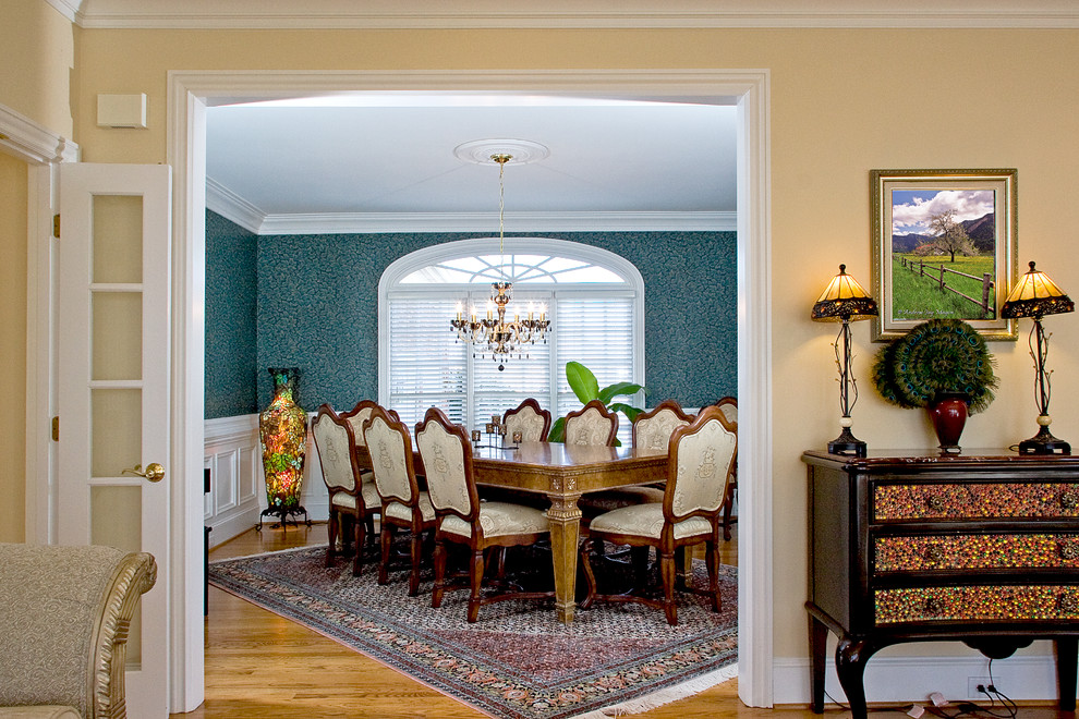 Idées déco pour une salle à manger classique avec un mur beige, un sol en bois brun et éclairage.