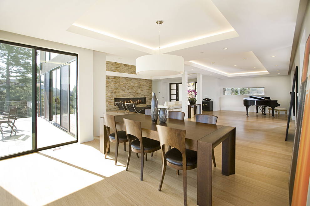 Foto di una sala da pranzo aperta verso il soggiorno design con pavimento in bambù
