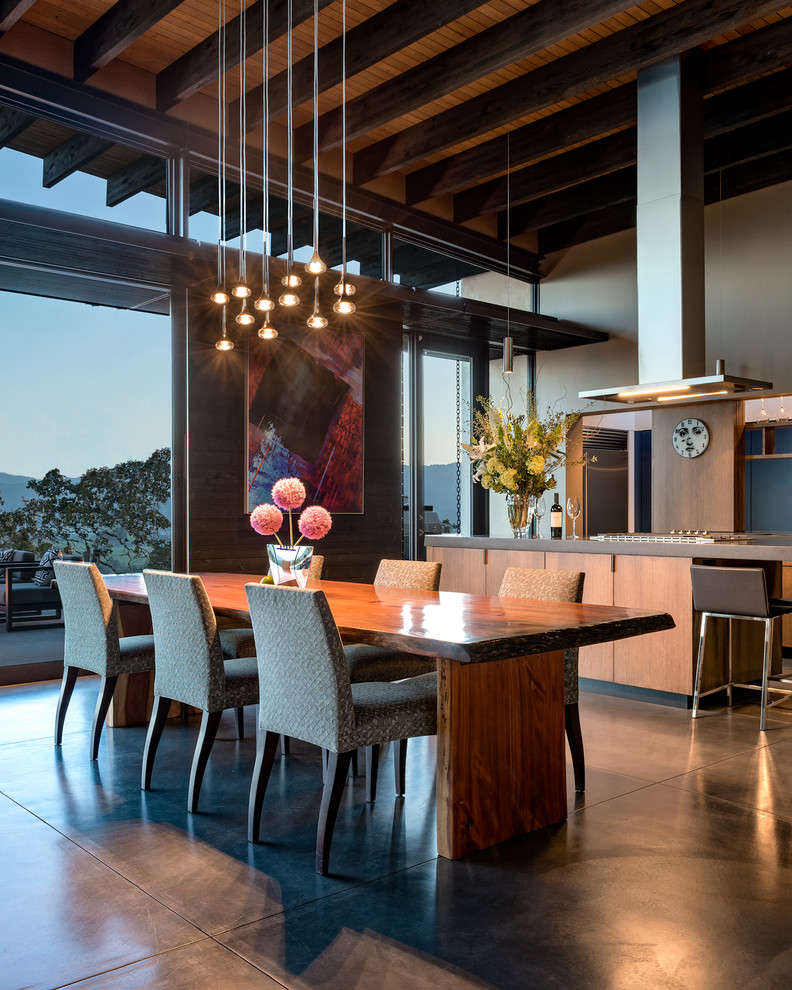 Exemple d'une salle à manger ouverte sur la cuisine tendance avec un mur gris, sol en béton ciré et un sol gris.