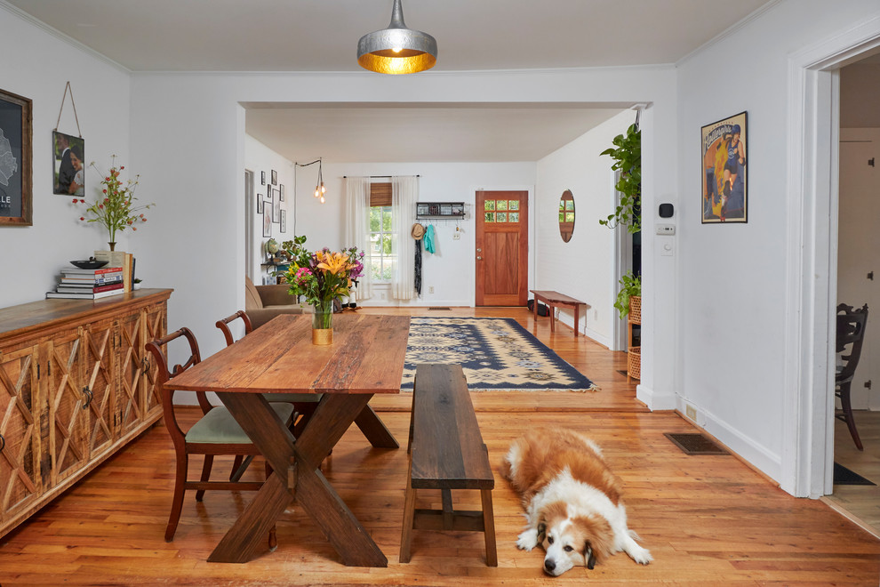 Exemple d'une salle à manger chic avec un mur blanc, un sol en bois brun et un sol marron.