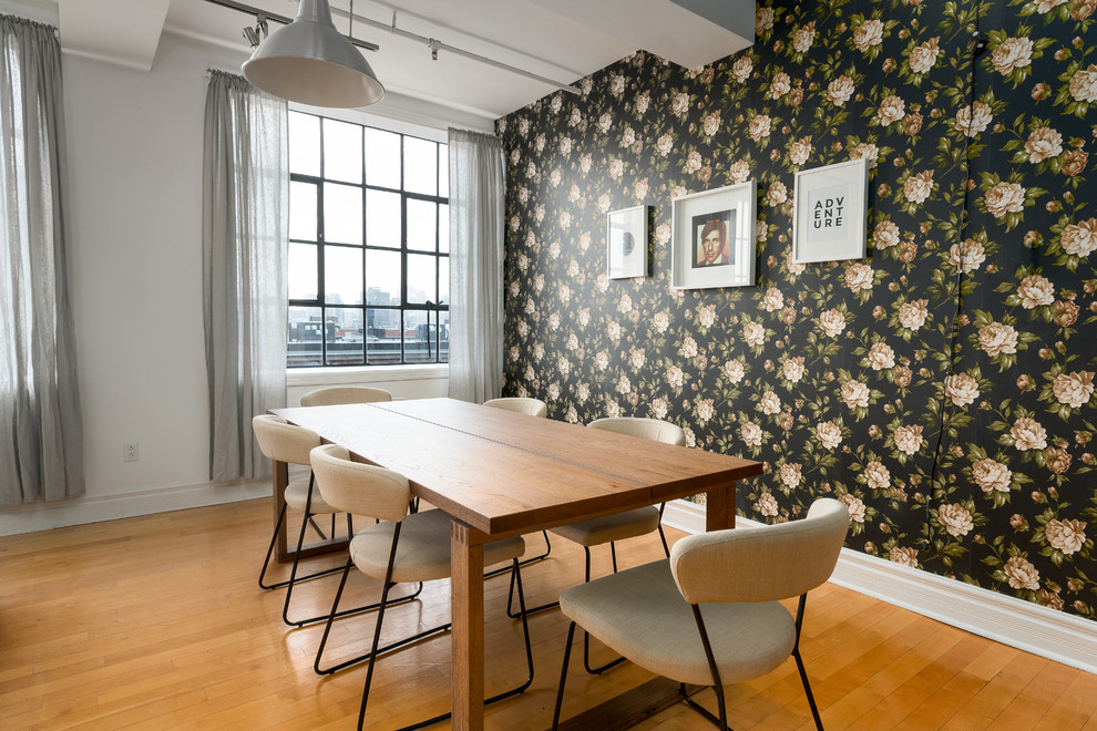 Immagine di una sala da pranzo design con pareti nere e pavimento in legno massello medio