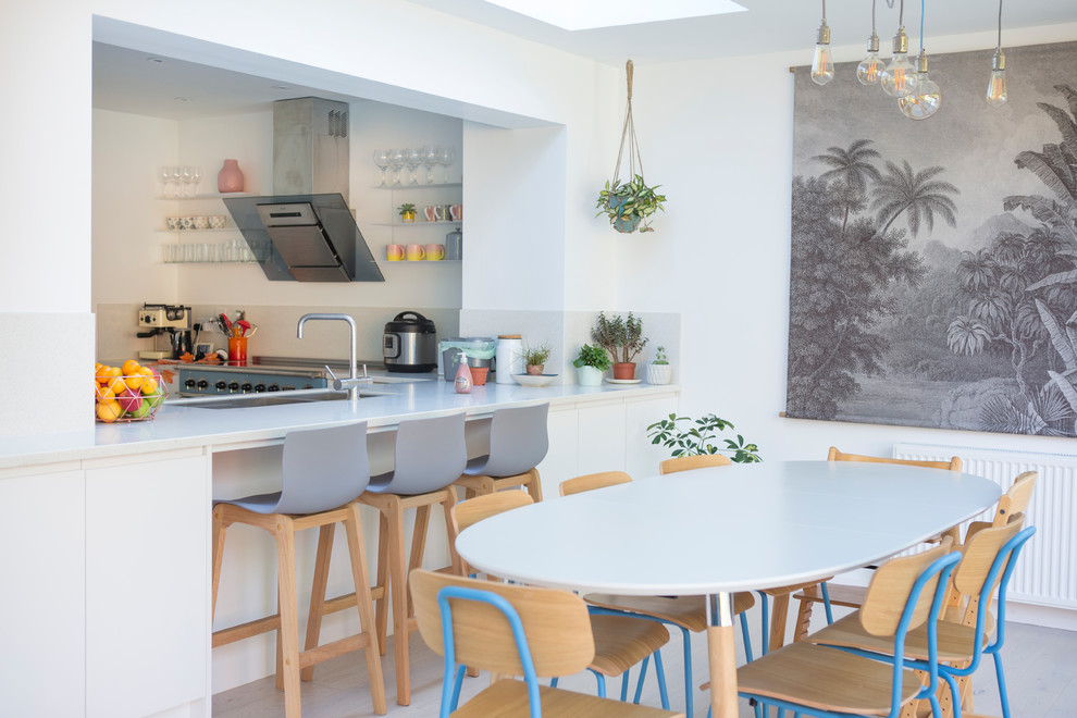 Idee per una sala da pranzo aperta verso la cucina tropicale con pareti bianche, nessun camino e pavimento grigio