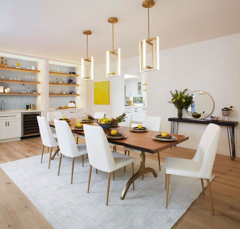 Aménagement d'une grande salle à manger ouverte sur la cuisine classique avec un mur blanc, parquet clair, une cheminée d'angle, un manteau de cheminée en plâtre et un sol blanc.