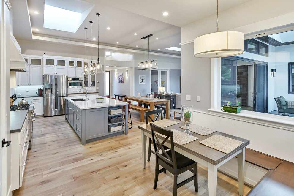 На фото: кухня-столовая среднего размера в стиле кантри с серыми стенами, светлым паркетным полом и коричневым полом без камина с