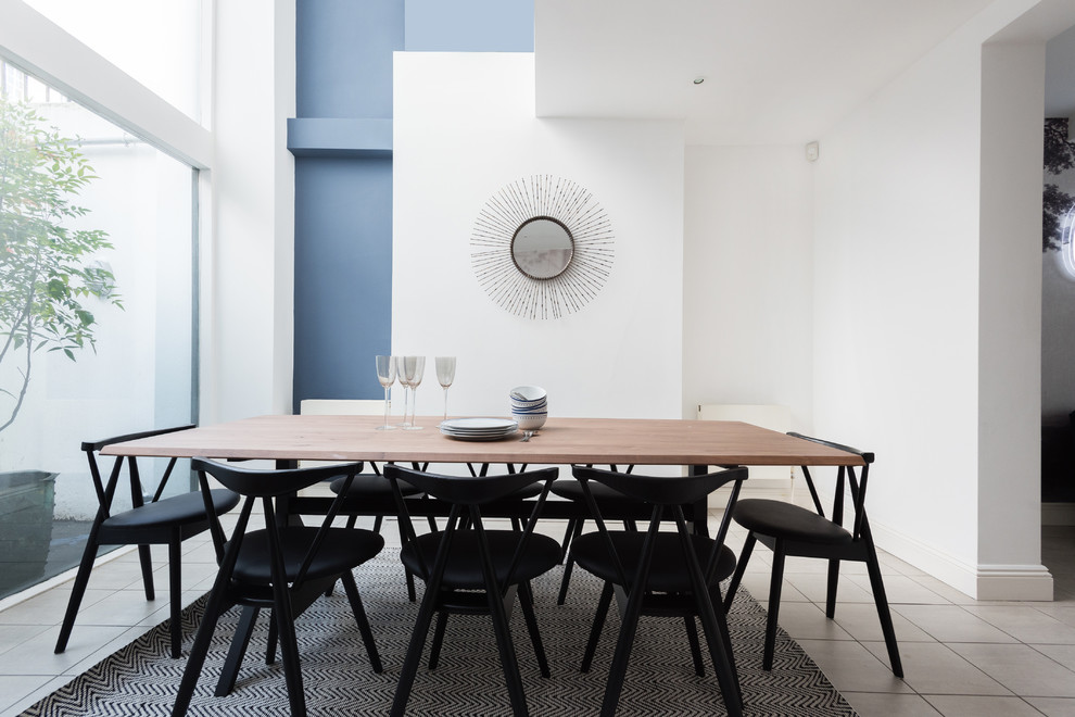 Design ideas for a contemporary enclosed dining room in London with white walls and grey floors.