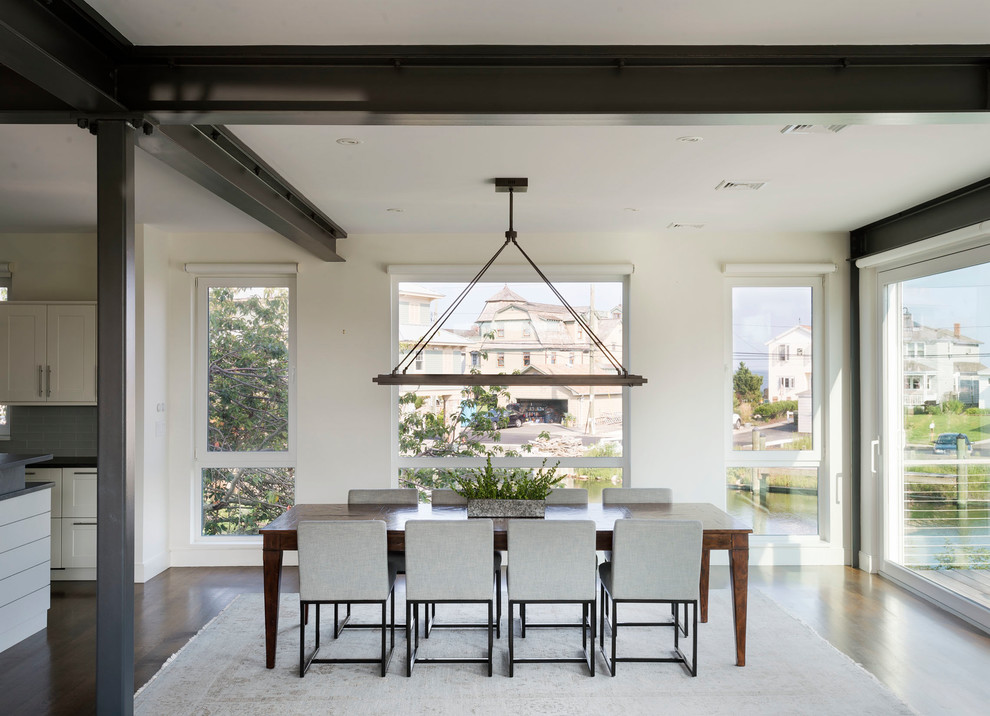 Foto di una sala da pranzo aperta verso la cucina stile marinaro di medie dimensioni con pareti bianche, parquet scuro e pavimento marrone