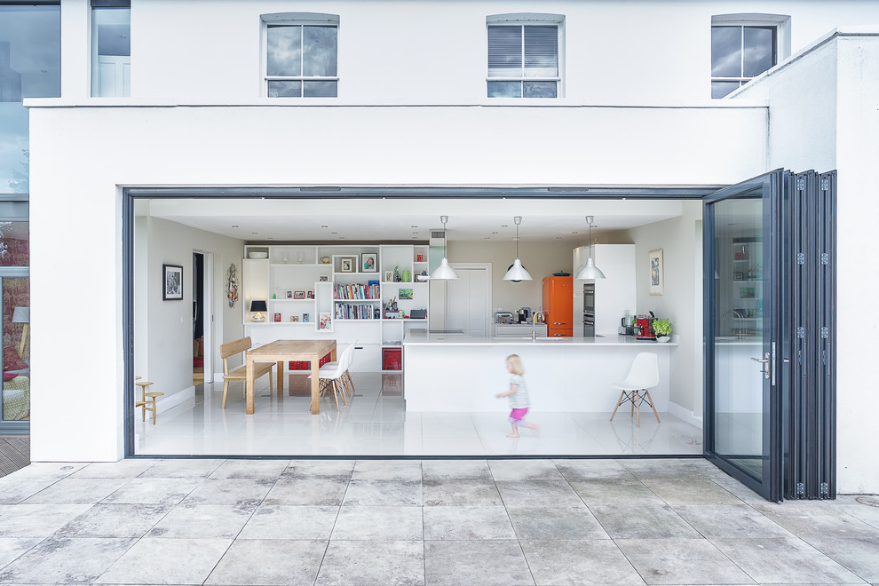 Ispirazione per una sala da pranzo aperta verso il soggiorno contemporanea con pareti bianche, pavimento in cemento e pavimento bianco