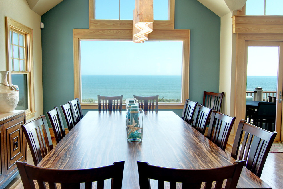 Cette image montre une salle à manger ouverte sur le salon marine de taille moyenne avec un mur beige, un sol en bois brun et aucune cheminée.