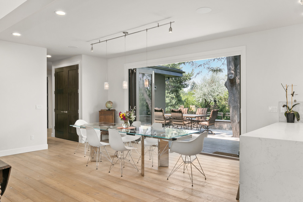 Ispirazione per una sala da pranzo aperta verso il soggiorno design di medie dimensioni con pareti bianche, pavimento in legno massello medio e pavimento marrone