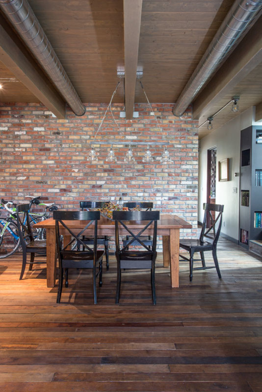 Imagen de comedor industrial de tamaño medio abierto con paredes rojas y suelo de madera en tonos medios