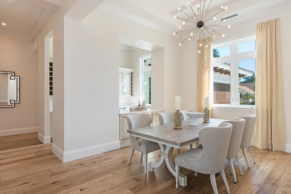 Example of a transitional light wood floor dining room design in Miami with gray walls