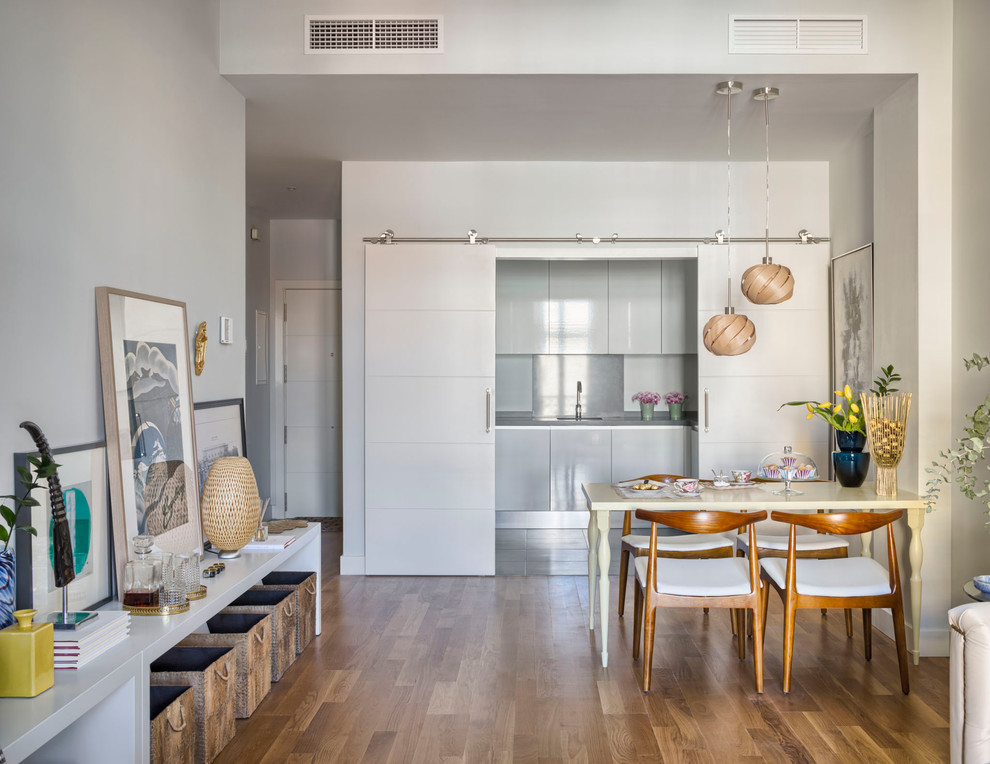 Стильный дизайн: кухня-столовая среднего размера в стиле фьюжн с белыми стенами и паркетным полом среднего тона без камина - последний тренд