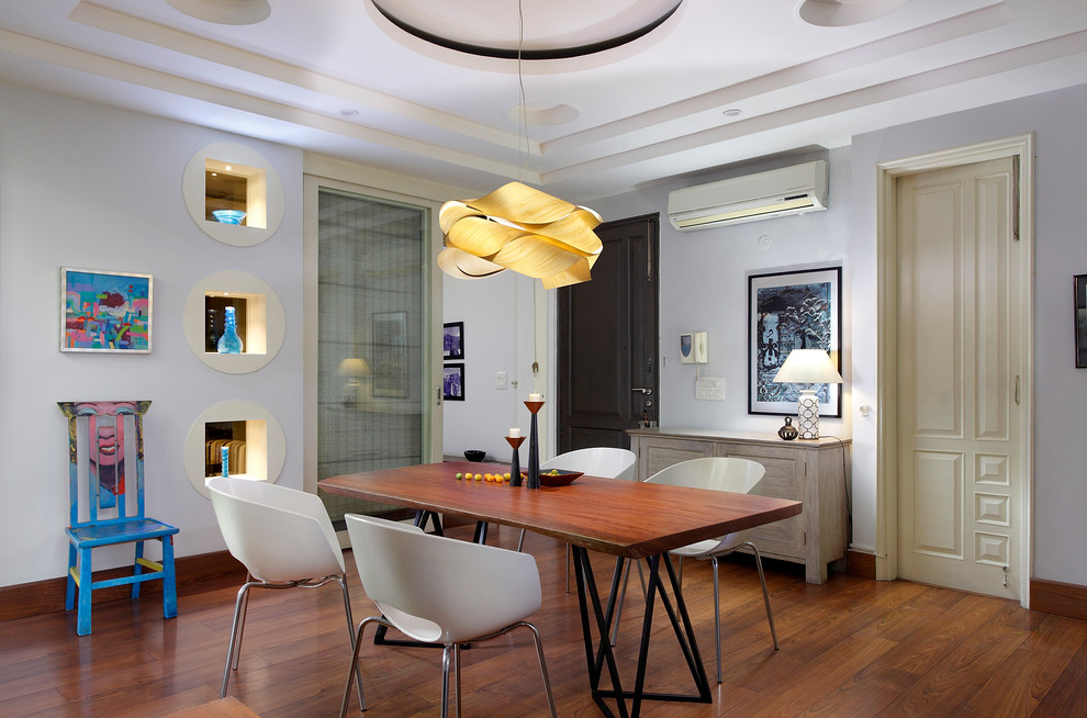 Idée de décoration pour une salle à manger design de taille moyenne avec un mur blanc, un sol en bois brun, un sol marron et éclairage.
