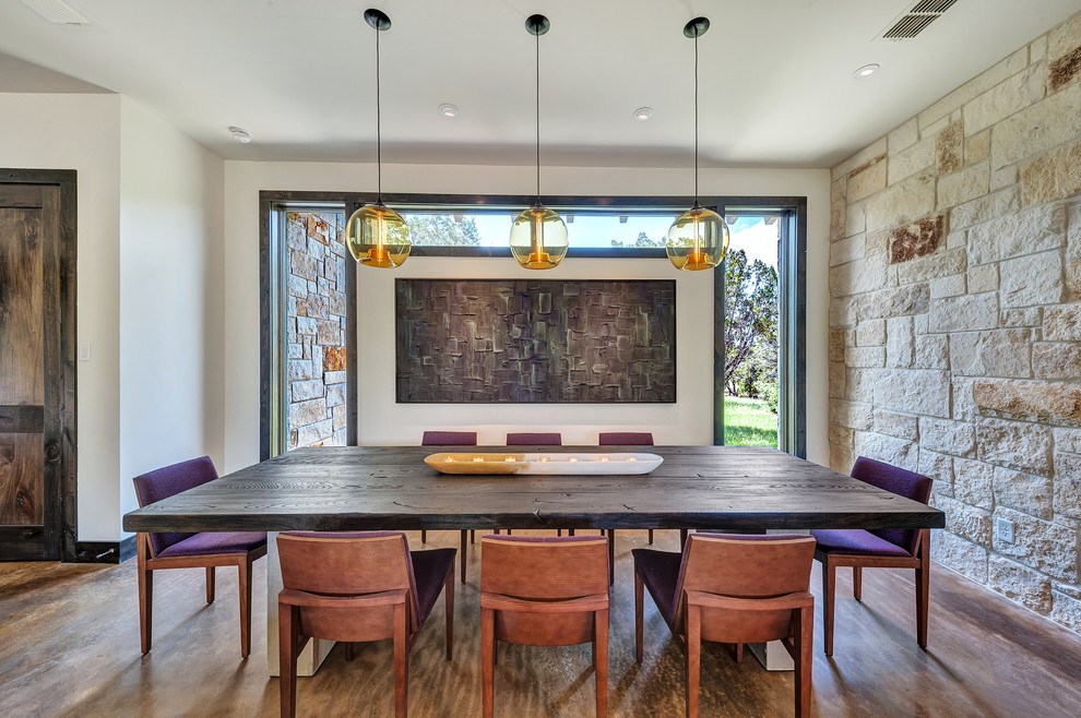 Contemporary dining room in Dallas with brown floors.