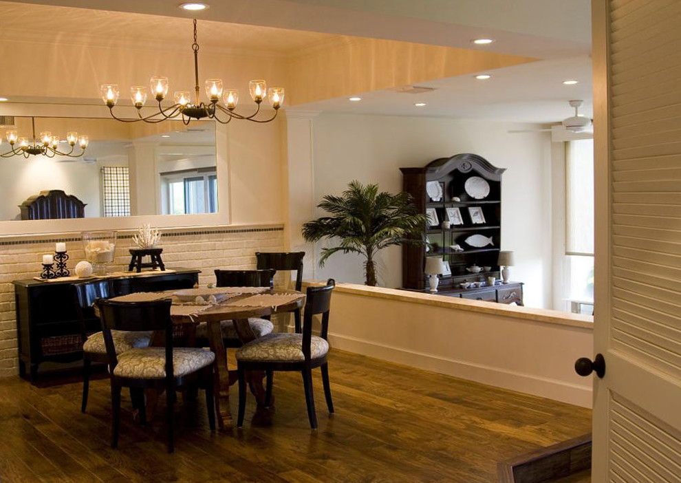 Esempio di una sala da pranzo aperta verso il soggiorno stile marinaro di medie dimensioni con pareti bianche, parquet scuro, pavimento marrone e nessun camino