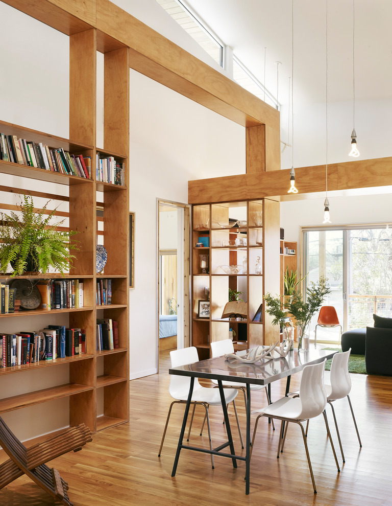 Great room - 1960s medium tone wood floor great room idea in Austin with white walls and no fireplace