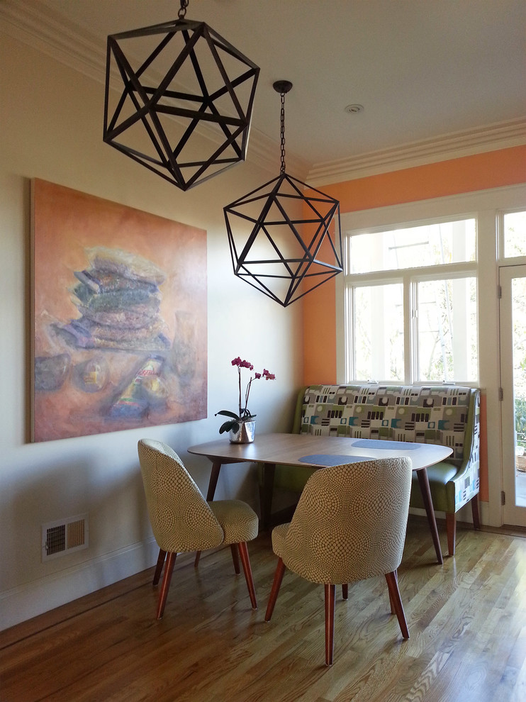Immagine di una piccola sala da pranzo aperta verso la cucina design con pareti beige, pavimento in legno massello medio, nessun camino e pavimento beige