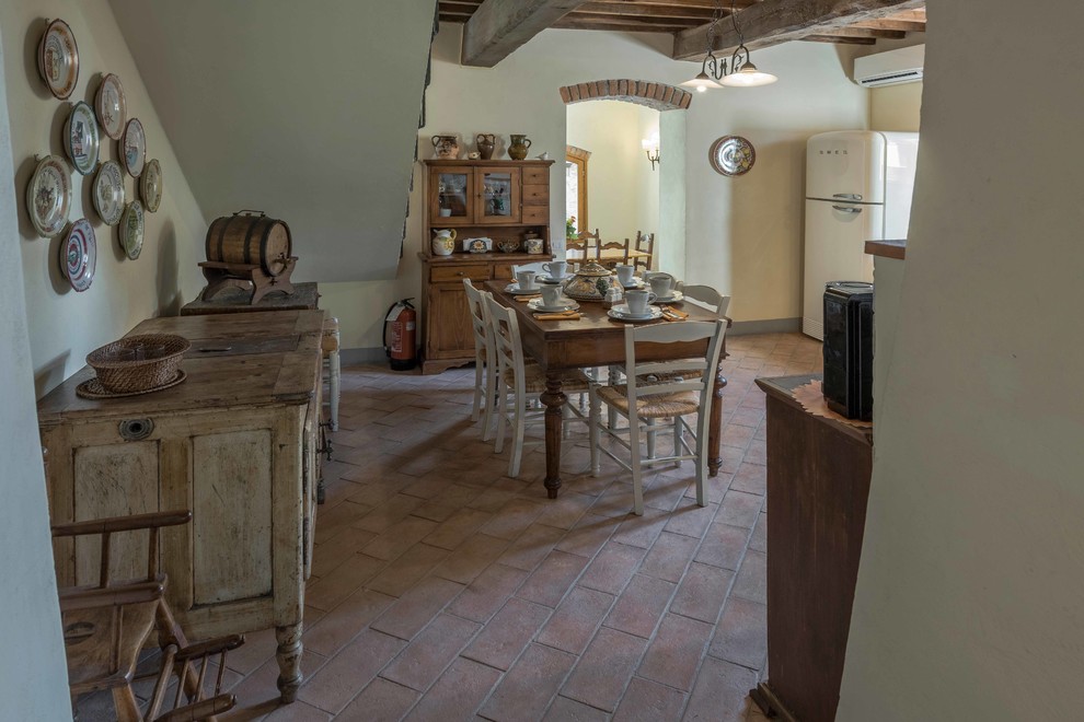 Inspiration pour une salle à manger ouverte sur la cuisine rustique de taille moyenne avec tomettes au sol.