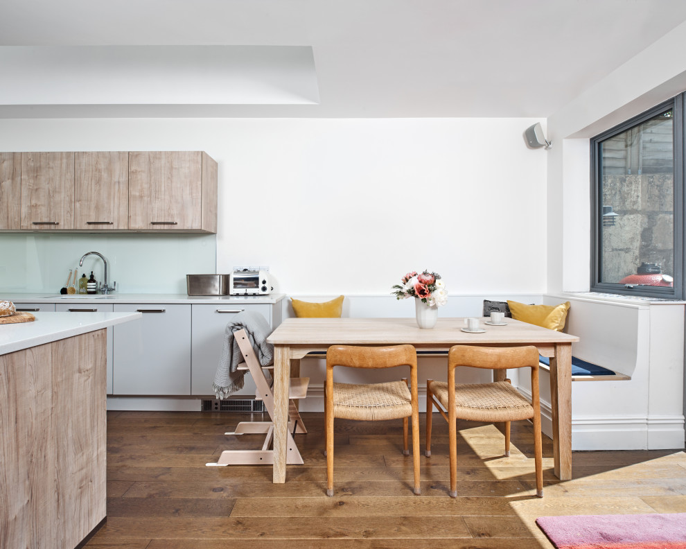 Mittelgroße Moderne Wohnküche mit weißer Wandfarbe, braunem Holzboden und braunem Boden in Sonstige