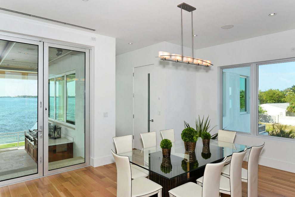 Große Wohnküche ohne Kamin mit weißer Wandfarbe und braunem Holzboden in Tampa