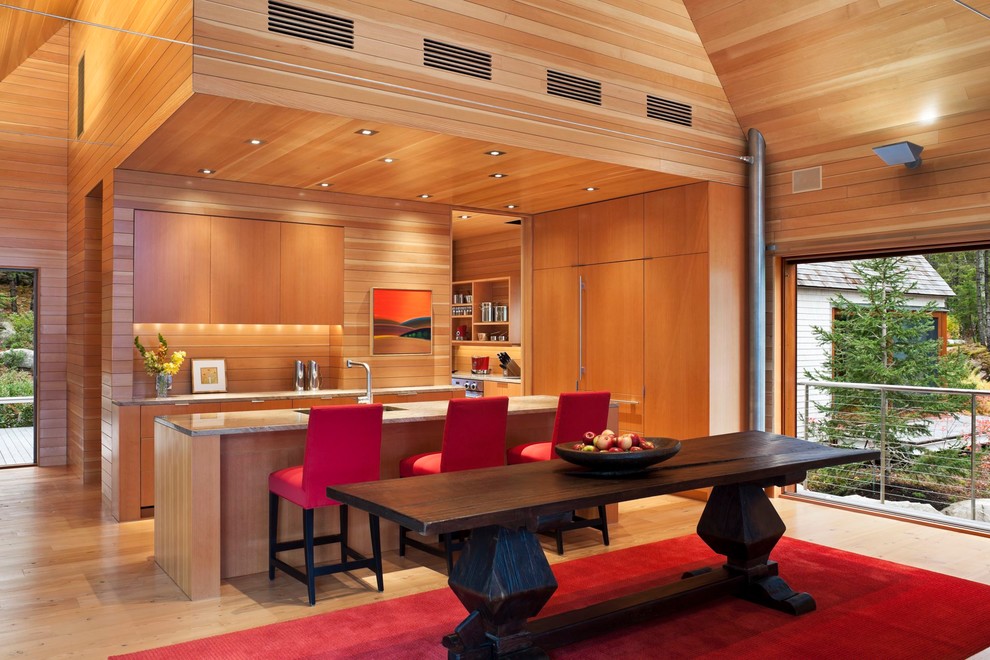 Foto di una sala da pranzo aperta verso la cucina design con pavimento in legno massello medio