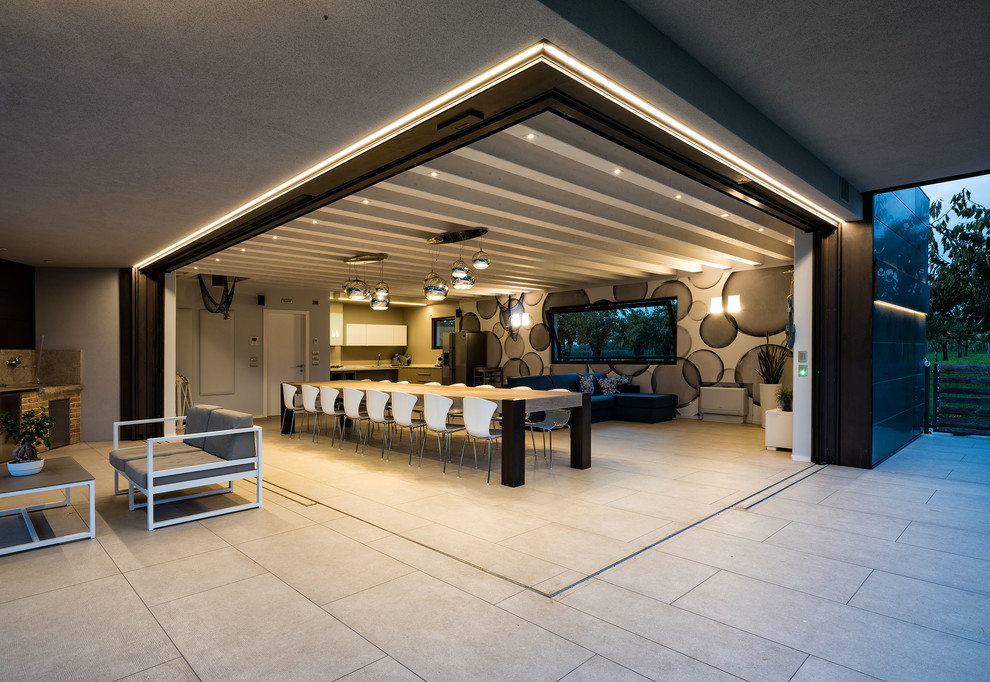 Foto di una grande sala da pranzo aperta verso il soggiorno minimal con pareti multicolore e pavimento grigio