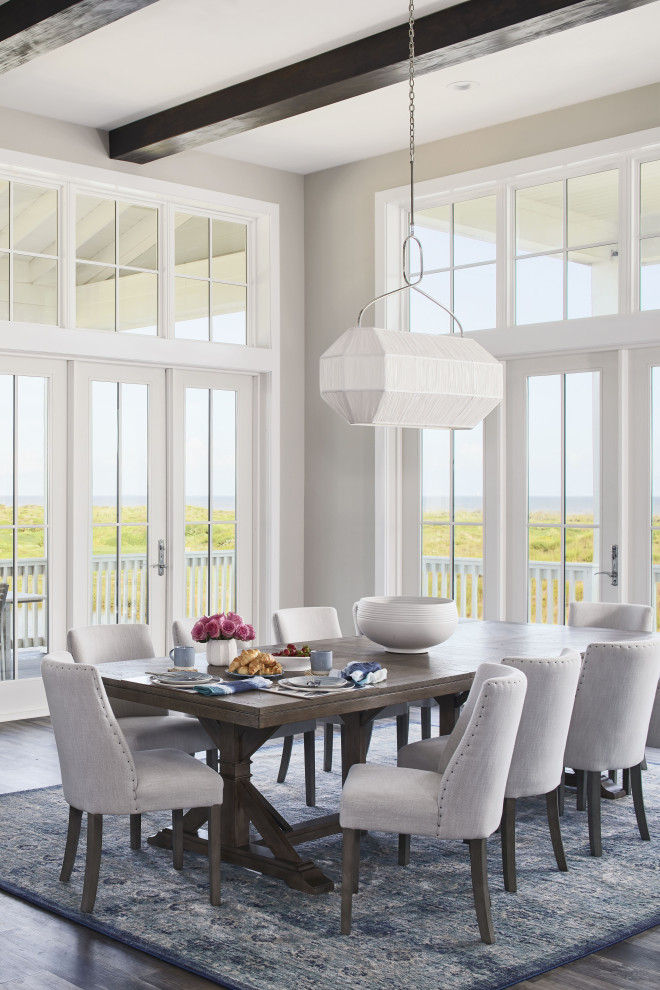 На фото: большая гостиная-столовая в морском стиле с серыми стенами, полом из винила, коричневым полом и балками на потолке с