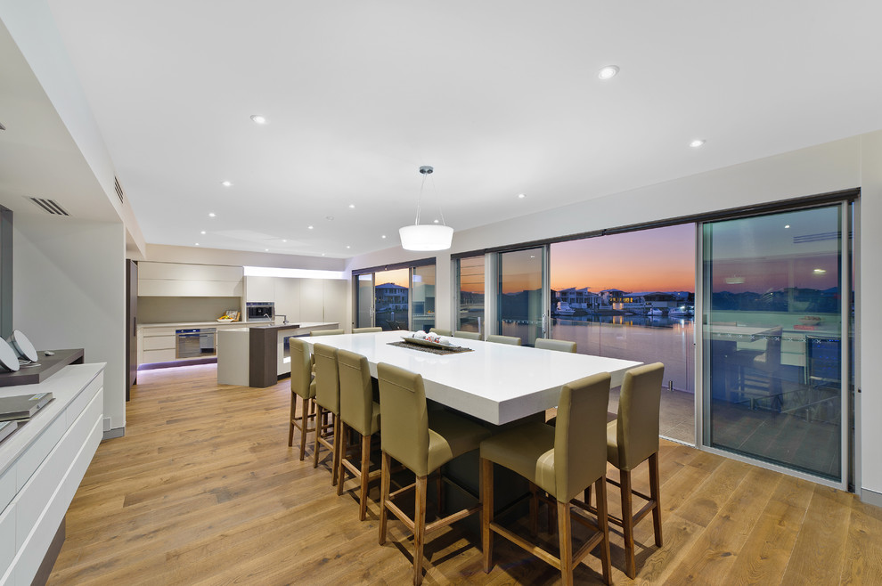 Moderne Wohnküche mit weißer Wandfarbe und braunem Holzboden in Sydney