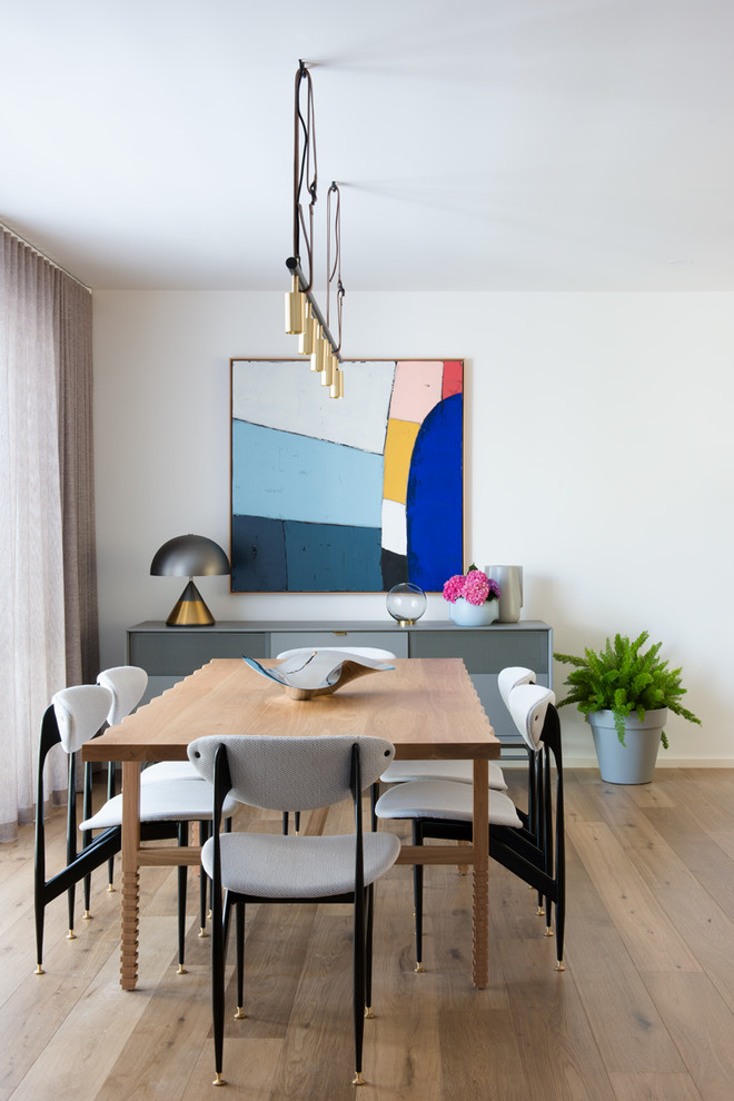 Esempio di una sala da pranzo aperta verso il soggiorno minimalista di medie dimensioni con pareti bianche, parquet chiaro, nessun camino e pavimento marrone