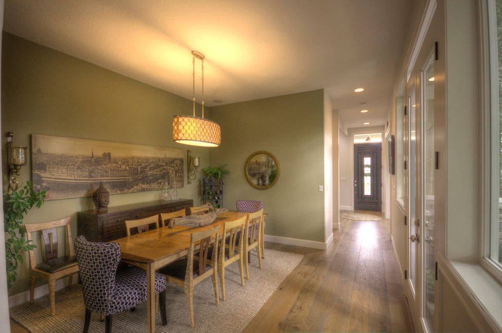 Aménagement d'une salle à manger ouverte sur le salon classique de taille moyenne avec un mur vert, un sol en bois brun et aucune cheminée.