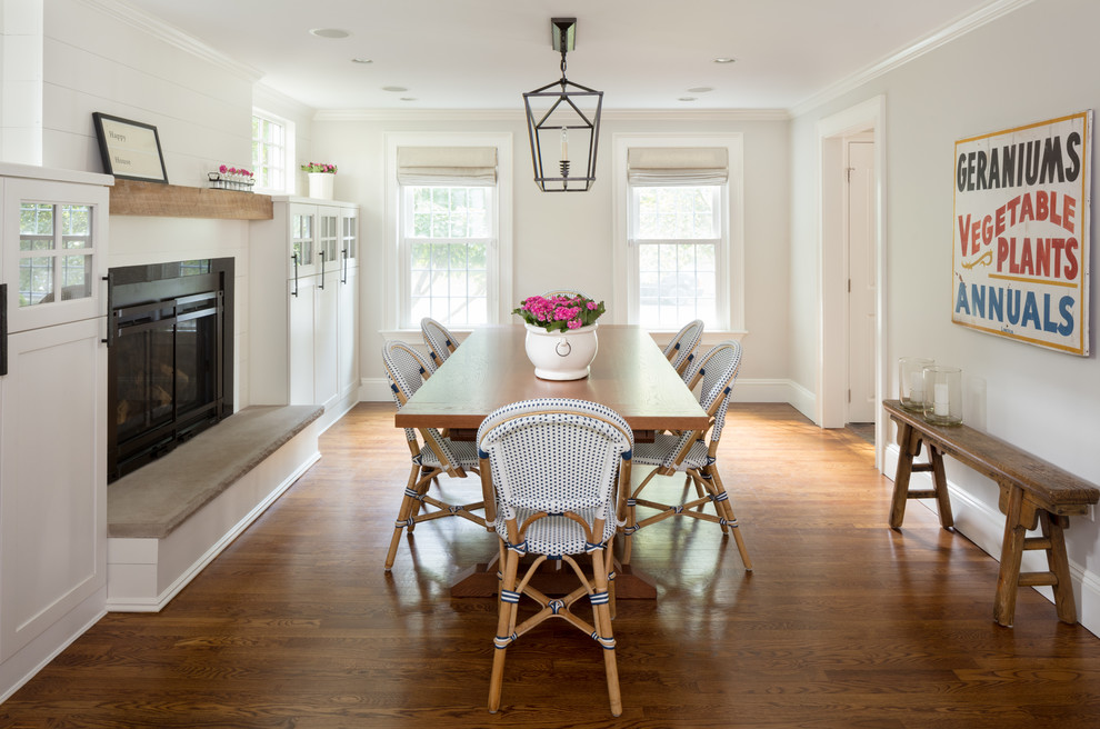 Example of a mid-sized transitional medium tone wood floor and brown floor dining room design in Boston with gray walls, a standard fireplace and a metal fireplace