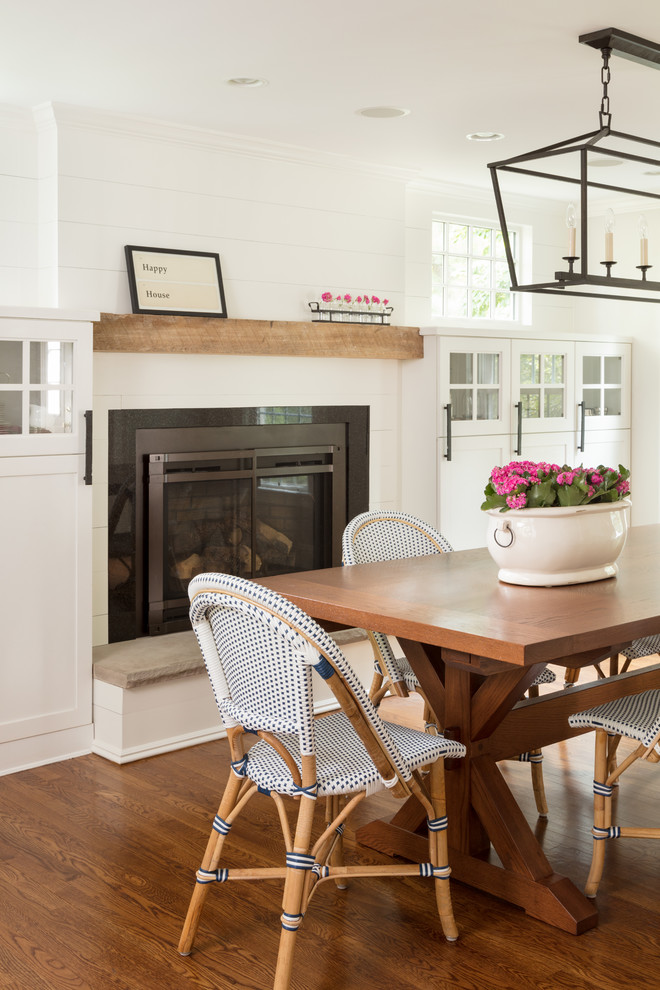 Mid-sized transitional medium tone wood floor and brown floor dining room photo in Boston with gray walls, a standard fireplace and a metal fireplace