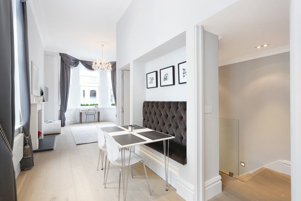 Kleines, Offenes Modernes Esszimmer mit grauer Wandfarbe, hellem Holzboden, Kamin und Kaminumrandung aus Holz in London