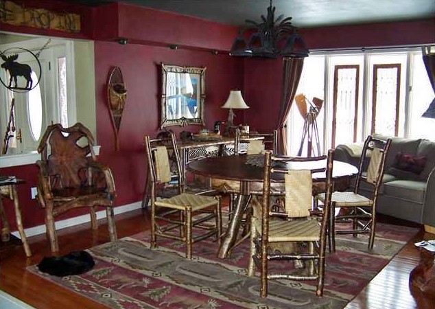 Foto di una sala da pranzo aperta verso il soggiorno rustica di medie dimensioni con pareti rosse e pavimento in legno massello medio