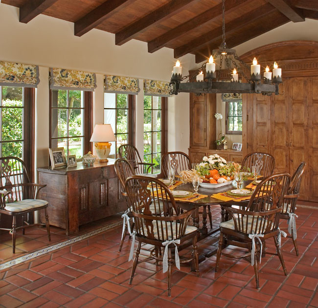 Aménagement d'une salle à manger classique fermée et de taille moyenne avec un mur beige, tomettes au sol, aucune cheminée et un sol rouge.
