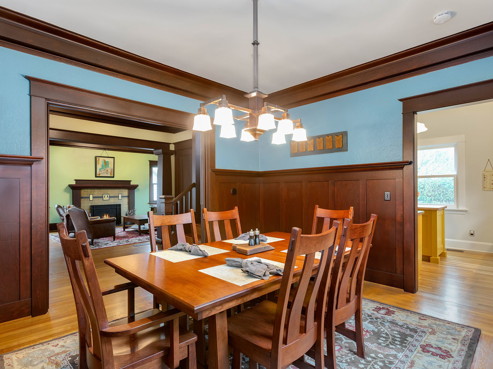 Foto di una grande sala da pranzo american style chiusa con pareti blu e parquet chiaro