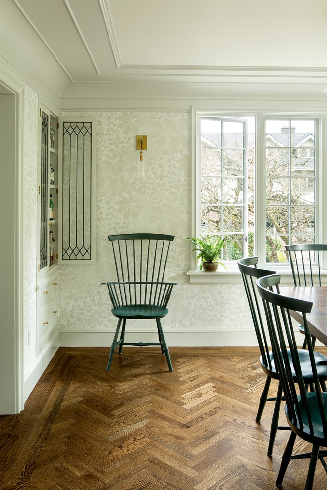 Immagine di una sala da pranzo tradizionale chiusa e di medie dimensioni con pareti bianche, pavimento in legno massello medio e pavimento marrone