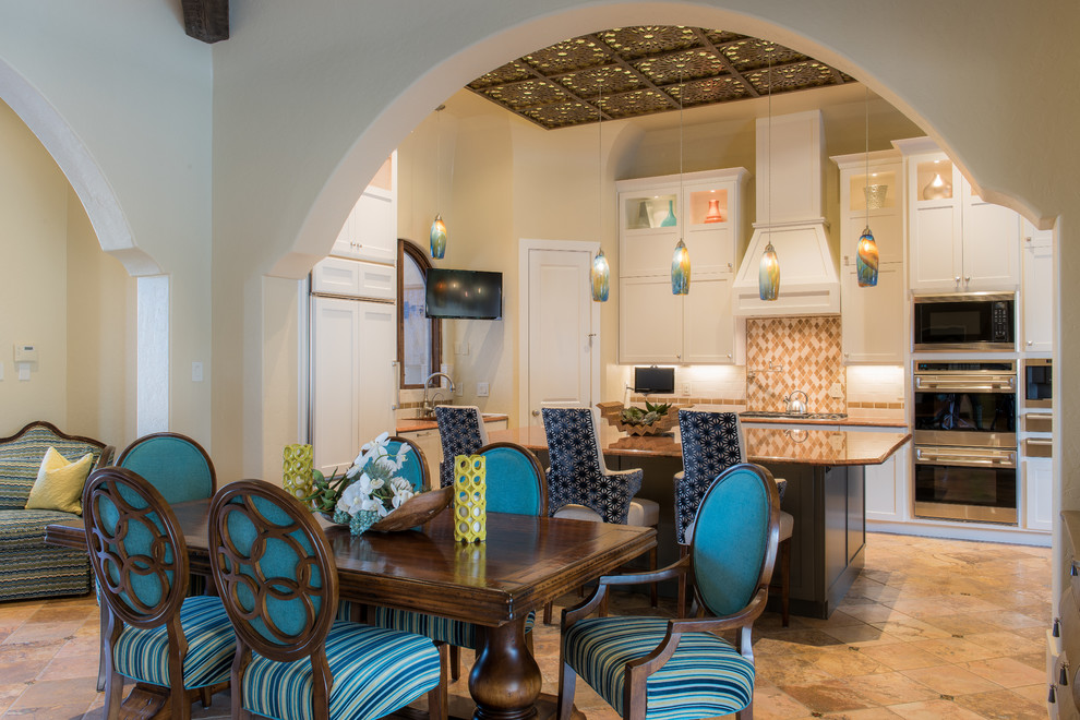 Photo of a small mediterranean kitchen/dining room in Dallas with beige walls and travertine flooring.